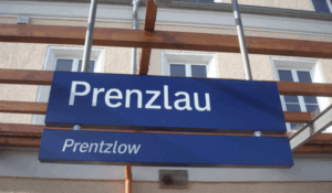 Ein Bahnhofsschild mit der deutschen Aufschrift "Prenzlau", darunter Niederdeutsch "Prentzlow"