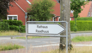 Hinweisschild mit der Aufschrift "Rathaus", darunter "Raadhuus"